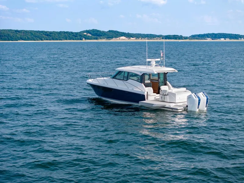 Slide: The Image of 2025 Tiara Yachts 43 LE cruising on open water with scenic coastline in background. - 9
