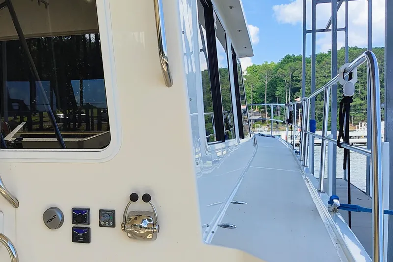 Slide: The Image of Side view of a 2009 Maine Cat P-47 yacht docked by a scenic lake. - 6