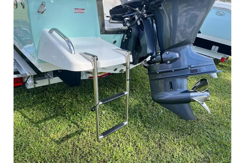 Slide: The Image of 2026 Key West 1720 Center Console boat with ladder and outboard motor on grass. - 5