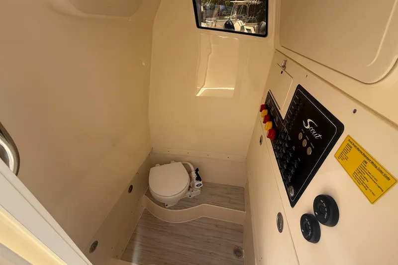 Slide: The Image of Interior of 2026 Scout 260 LXF boat featuring a compact marine toilet. - 12