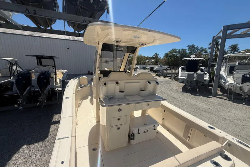 Slide: The Image of 2026 Scout 260 LXF boat interior with seating and storage, docked outdoors. - 3