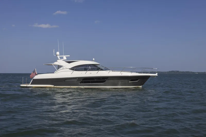 Slide: The Image of 2016 Riviera 5000 Sport Yacht cruising on open water under clear blue sky. - 1