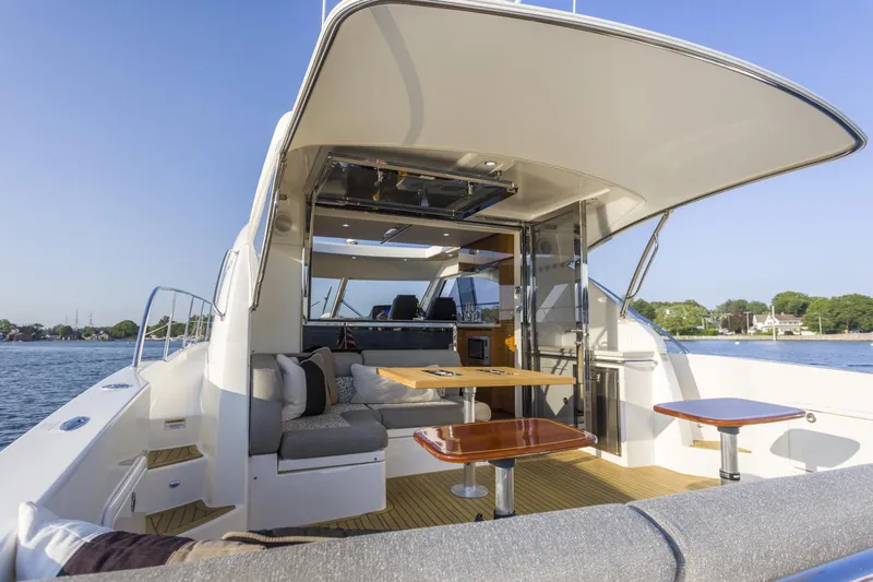 Slide: The Image of 2016 Riviera 5000 Sport Yacht with spacious deck and luxurious seating on calm waters. - 13