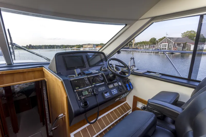 Slide: The Image of Interior helm of 2016 Riviera 5000 Sport Yacht with navigation controls and waterfront view. - 20