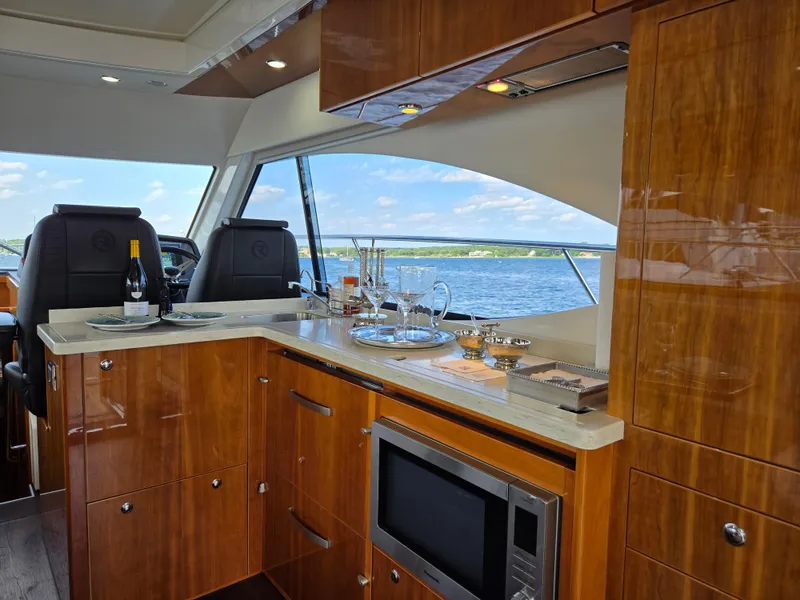 Slide: The Image of Luxurious interior of 2016 Riviera 5000 Sport Yacht with elegant wood finish and scenic ocean view. - 21