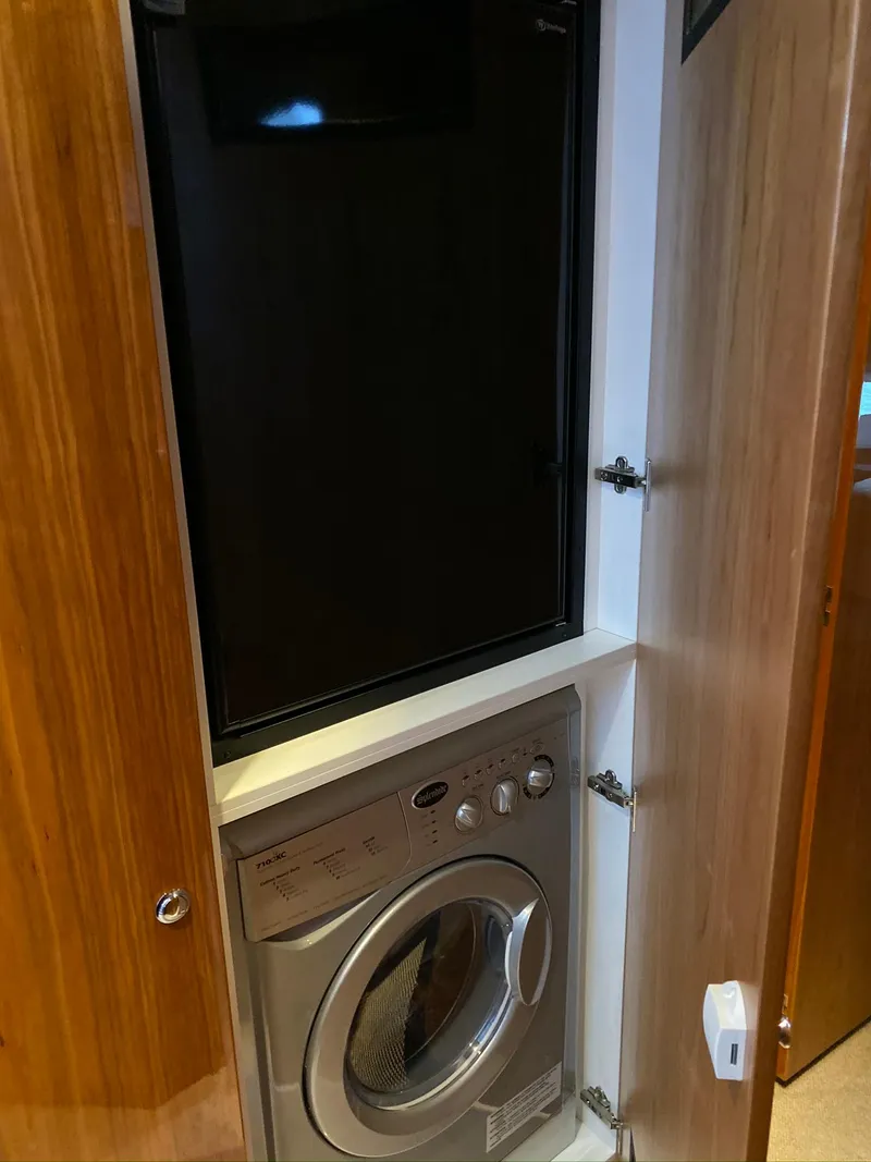 Slide: The Image of Laundry area with washer and dryer in 2016 Riviera 5000 Sport Yacht. - 22