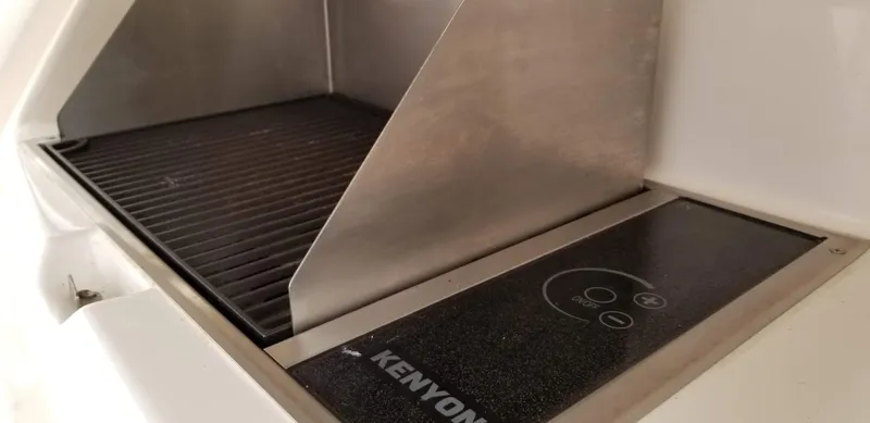 Slide: The Image of Kenyon grill on 2016 Riviera 5000 Sport Yacht, featuring sleek stainless steel design. - 23