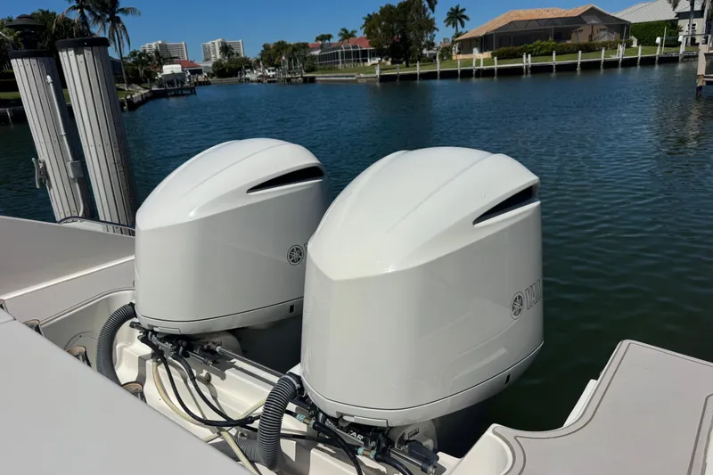 Slide: The Image of 2016 Pursuit DC 325 Dual Console with twin Yamaha outboard engines on a sunny waterfront. - 16
