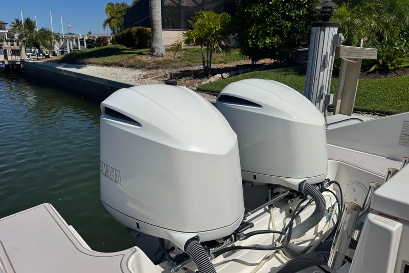 Slide: The Image of 2016 Pursuit DC 325 Dual Console with twin Yamaha outboard engines docked by a canal. - 17