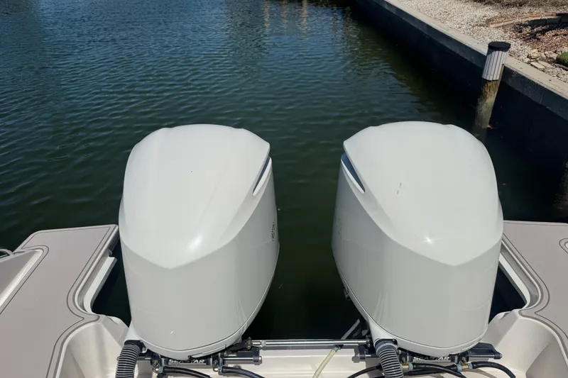 Slide: The Image of 2016 Pursuit DC 325 Dual Console with twin outboard engines on water. - 18