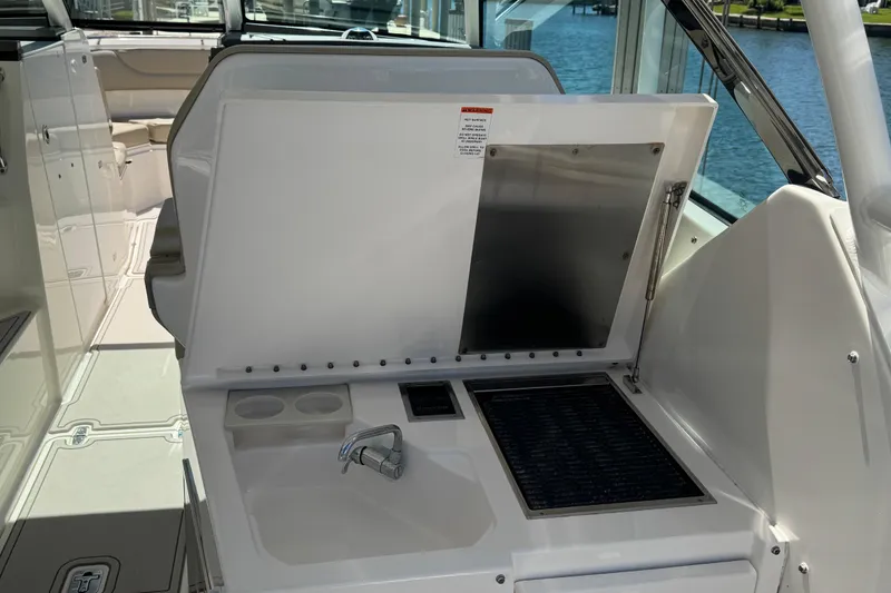 Slide: The Image of 2016 Pursuit DC 325 Dual Console boat interior with sink and seating area. - 22