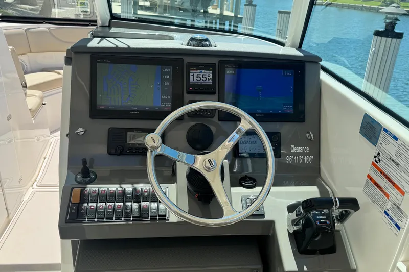 Slide: The Image of Cockpit of 2016 Pursuit DC 325 Dual Console with navigation screens and steering wheel. - 26