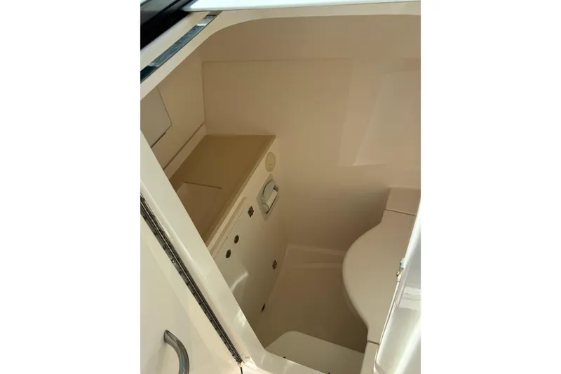 Slide: The Image of Interior of 2016 Pursuit DC 325 Dual Console boat, featuring compact bathroom amenities. - 27