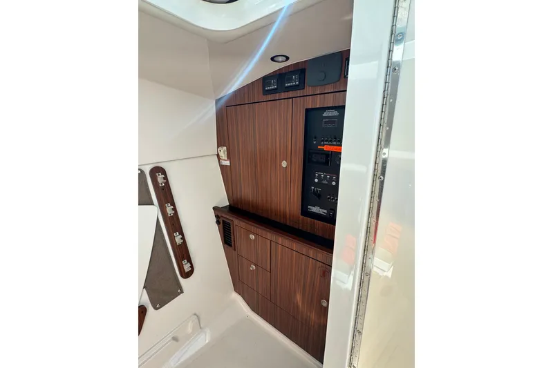 Slide: The Image of Interior view of 2016 Pursuit DC 325 Dual Console boat's control panel and cabinetry. - 28
