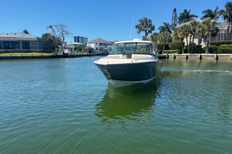 Slide: The Image of 2016 Pursuit DC 325 Dual Console boat cruising in a scenic waterfront area. - 33