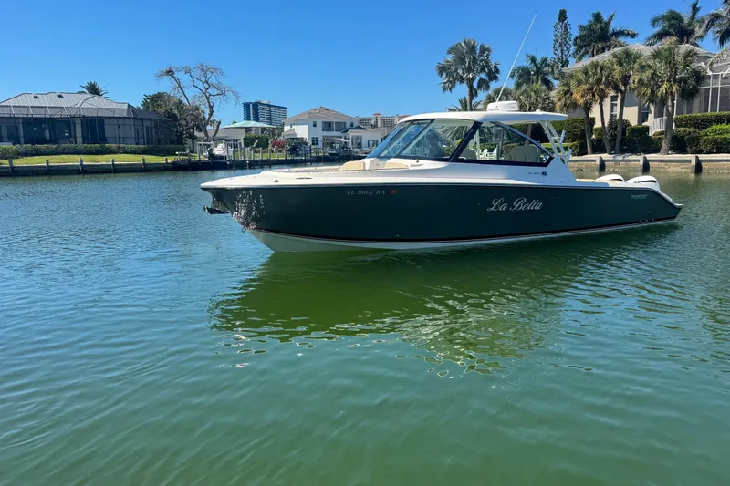 Slide: The Image of 2016 Pursuit DC 325 Dual Console boat named "La Bella" on calm water near waterfront homes. - 39