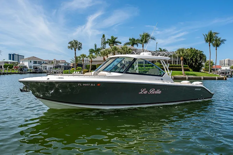 Slide: The Image of 2016 Pursuit DC 325 Dual Console boat named "La Bella" on a scenic waterfront. - 48