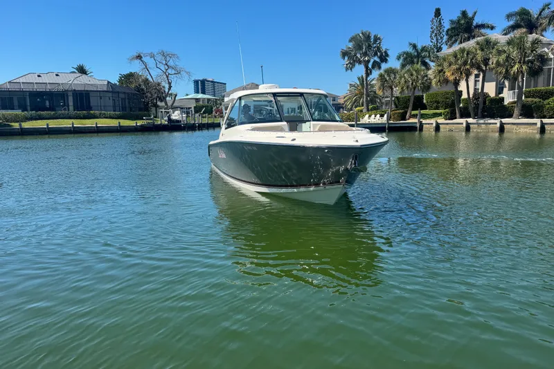 Slide: The Image of 2016 Pursuit DC 325 Dual Console boat cruising on a sunny waterway. - 6