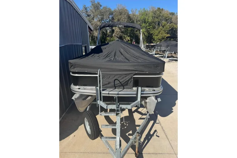 Slide: The Image of 2022 Lowe Ultra 182 Fish & Cruise boat covered on a trailer, parked outdoors. - 5