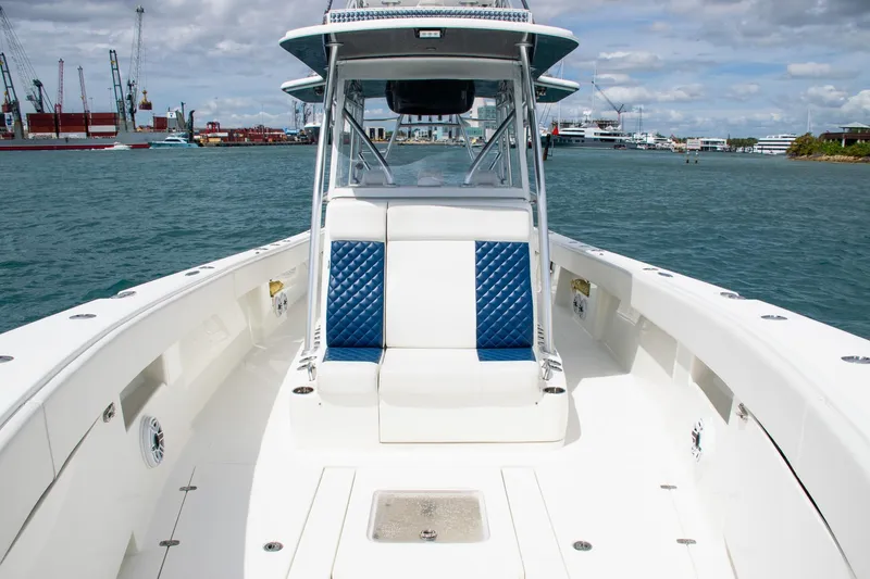 Slide: The Image of 2022 SeaVee 390Z boat with blue and white seating, docked in a harbor. - 12