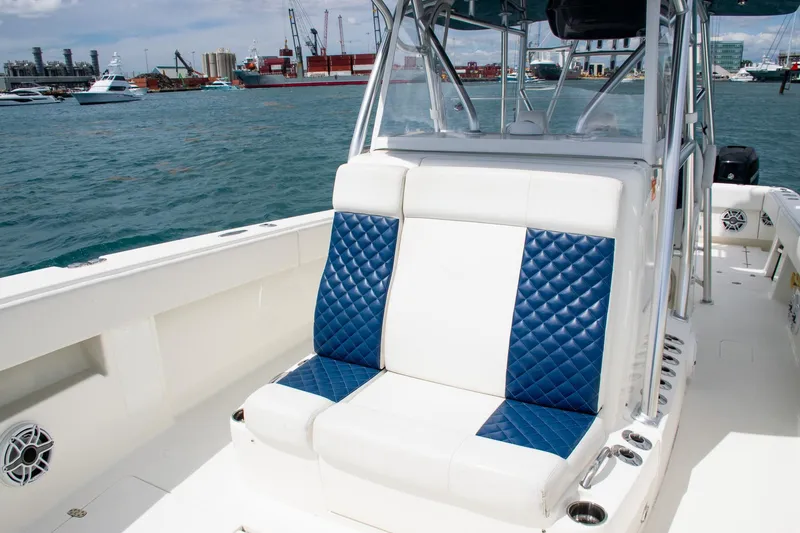 Slide: The Image of 2022 SeaVee 390Z boat with blue and white seating, docked in a marina. - 14