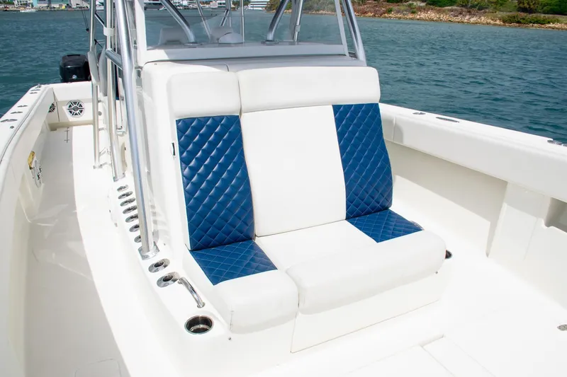 Slide: The Image of 2022 SeaVee 390Z boat with blue and white seating, docked on calm water. - 15