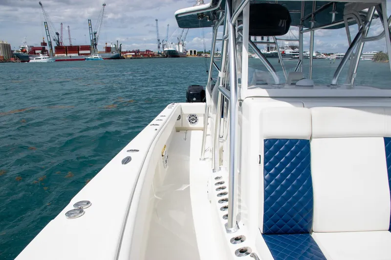 Slide: The Image of 2022 SeaVee 390Z boat with blue and white seating, docked in a harbor. - 19