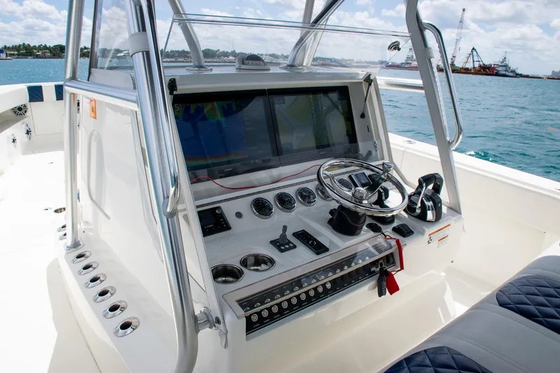 Slide: The Image of 2022 SeaVee 390Z boat dashboard with steering wheel and navigation screens on open water. - 20