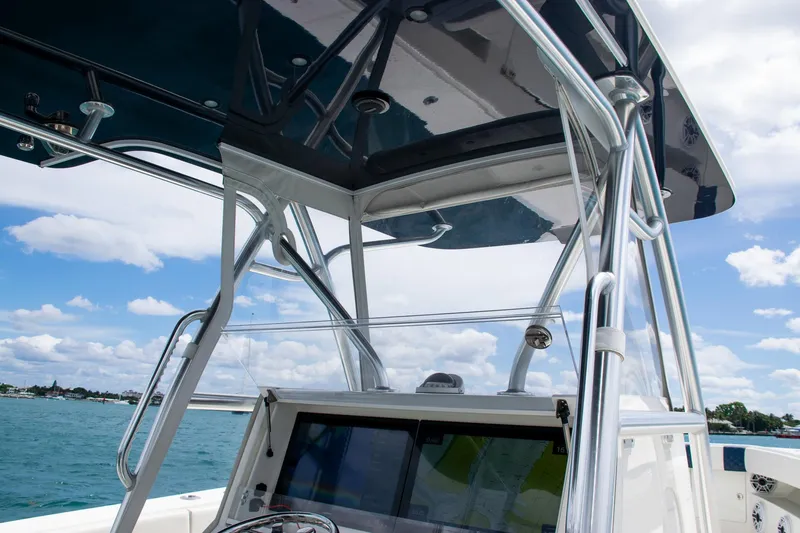 Slide: The Image of 2022 SeaVee 390Z boat console with T-top against a blue sky and ocean backdrop. - 24