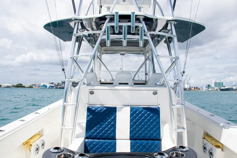 Slide: The Image of 2022 SeaVee 390Z boat with blue seating, docked in a marina under cloudy skies. - 38