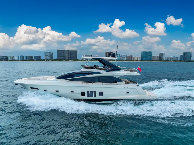 Slide: The Image of Astondoa 72 GLX 2013 yacht cruising on open water with city skyline backdrop. - 12