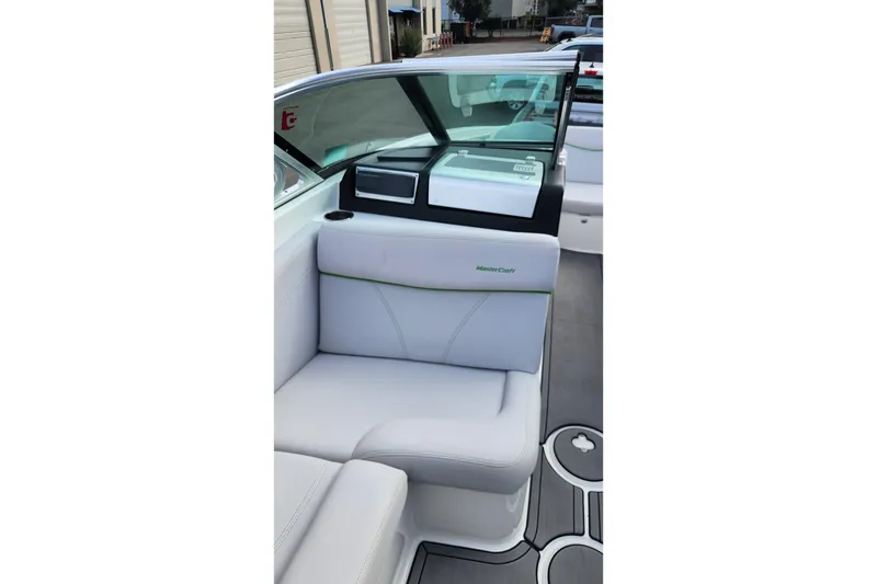 Slide: The Image of 2017 MasterCraft X23 boat interior with white seating and modern dashboard design. - 12