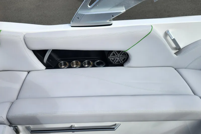 Slide: The Image of 2017 MasterCraft X23 boat interior with white seating, cup holders, and speaker. - 13