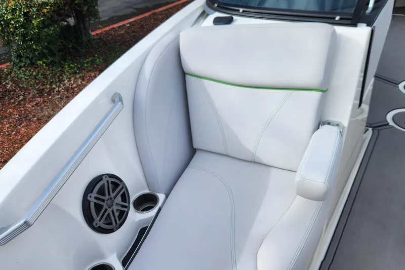 Slide: The Image of 2017 MasterCraft X23 boat interior with white seating, speaker, and cup holders. - 14