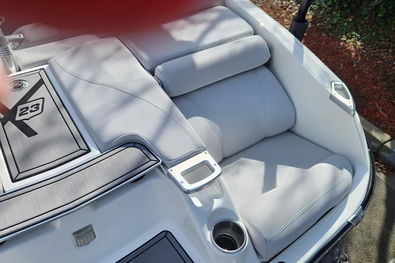 Slide: The Image of 2017 MasterCraft X23 boat interior with cushioned seating and cup holders. - 20