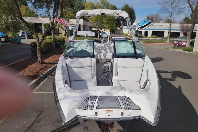 Slide: The Image of 2017 MasterCraft X23 boat with white interior, parked outdoors on a sunny day. - 21