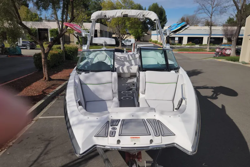 Slide: The Image of 2017 MasterCraft X23 boat with white seating, parked outdoors on a sunny day. - 22