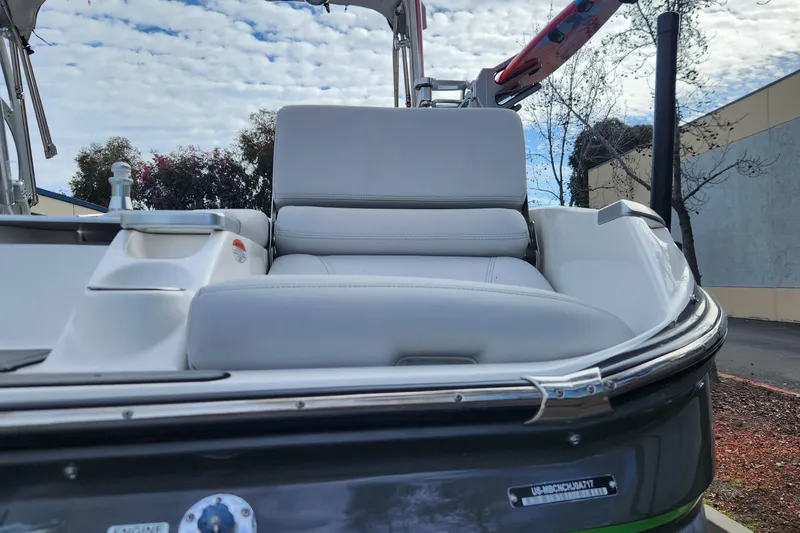 Slide: The Image of 2017 MasterCraft X23 boat with white seating, parked outdoors under a cloudy sky. - 24