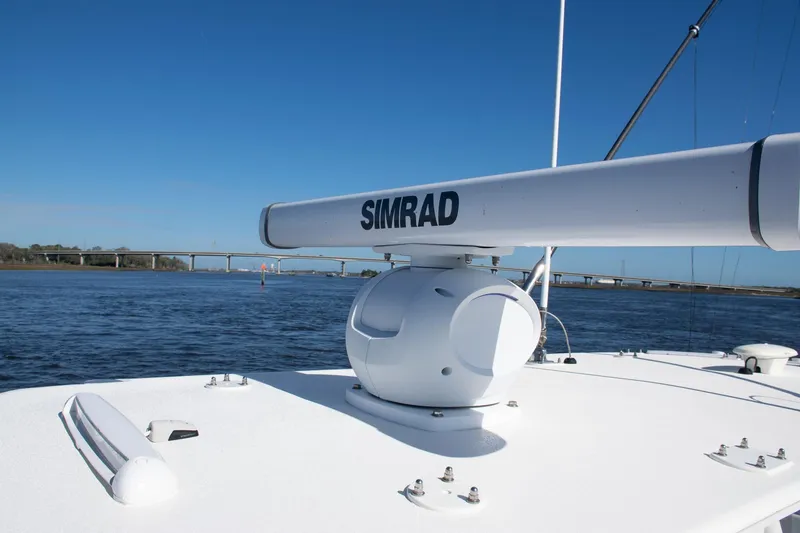 Slide: The Image of 2022 SeaVee 322Z boat with Simrad radar on calm water, bridge in background. - 16
