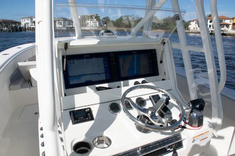 Slide: The Image of 2022 SeaVee 322Z boat helm with dual displays and steering wheel on water. - 31