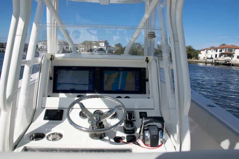 Slide: The Image of 2022 SeaVee 322Z boat helm with dual displays and steering wheel on a sunny day. - 38
