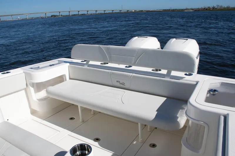 Slide: The Image of 2022 SeaVee 322Z boat interior with seating, ocean view, and bridge in background. - 43
