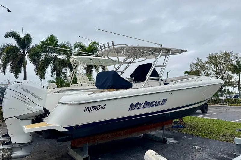 The Image of 2013 Intrepid 327 Cuddy boat on display with palm trees in the background. - 1