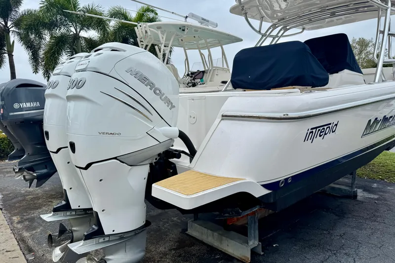 Slide: The Image of 2013 Intrepid 327 Cuddy boat with twin Mercury Verado engines, docked outdoors. - 3