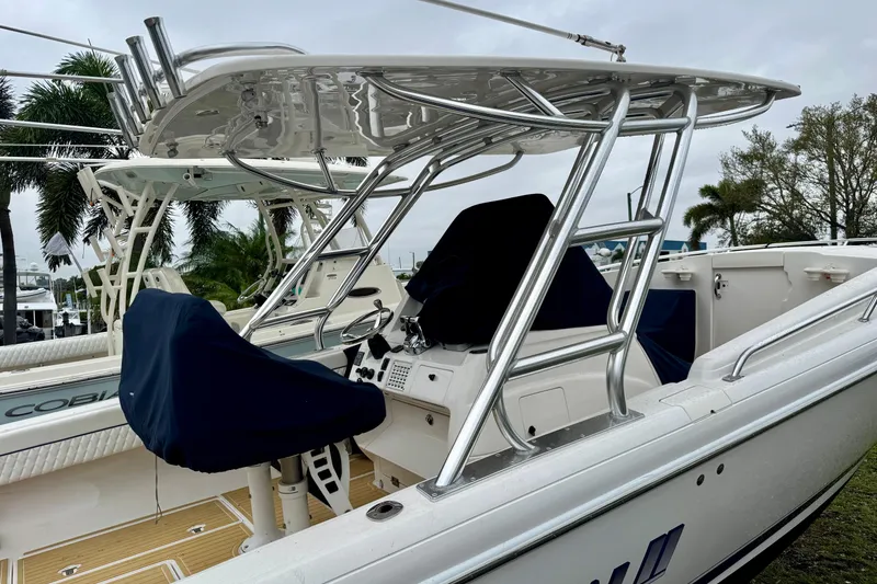 Slide: The Image of 2013 Intrepid 327 Cuddy boat with covered helm, sleek design, and stainless steel framework. - 4