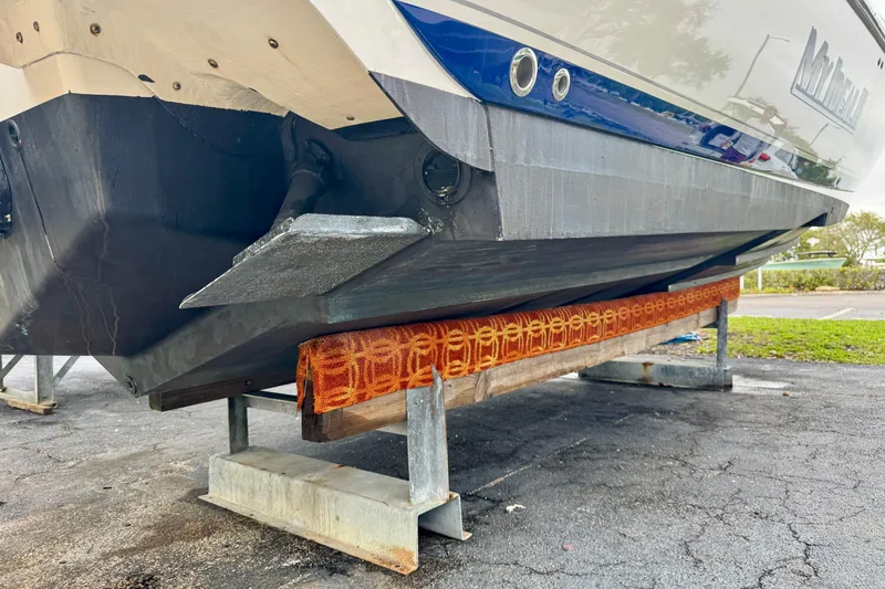 Slide: The Image of 2013 Intrepid 327 Cuddy boat on dry dock, showing hull and support structure. - 6