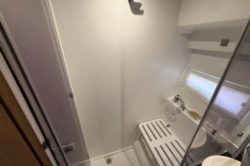 Slide: The Image of Bathroom interior of 2020 Jeanneau NC 1095 boat, featuring shower and window. - 10