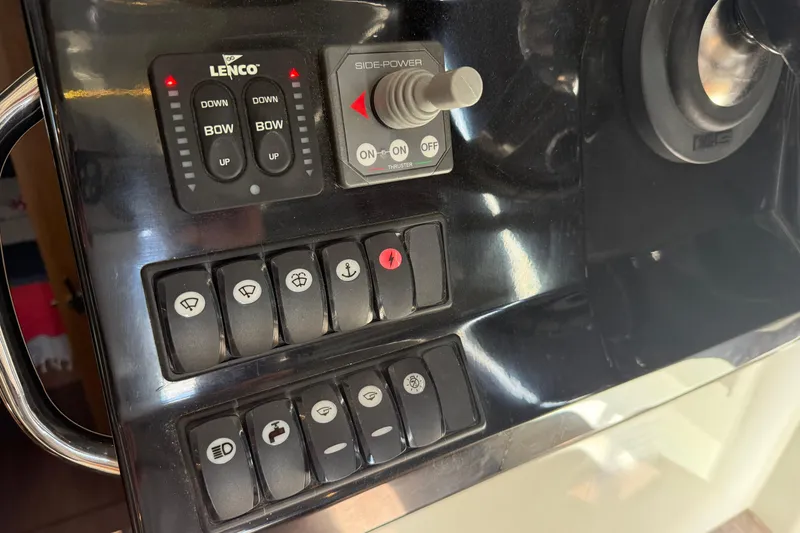 Slide: The Image of Control panel of a 2020 Jeanneau NC 1095 boat with various switches and controls. - 13
