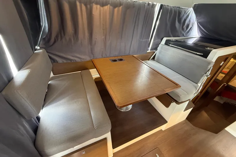 Slide: The Image of Interior of 2020 Jeanneau NC 1095 boat with cozy seating and wooden table. - 3