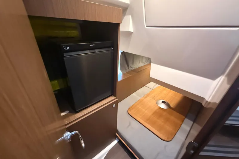 Slide: The Image of Interior cabin of 2020 Jeanneau NC 1095 with compact fridge and cozy seating area. - 6
